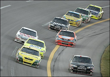 Tony Stewart, front left, leads a pack of cars through the tri-oval on the final lap of the NASCAR Sprint Cups Series' AMP Energy 500 auto race at Talladega Superspeedway in Talladega, Ala., Sunday, Oct. 5, 2008. At right is Regan Smith (01) who passed the finish line first but was disqualified for passing below the yellow line. (AP Photo/Dave Martin)